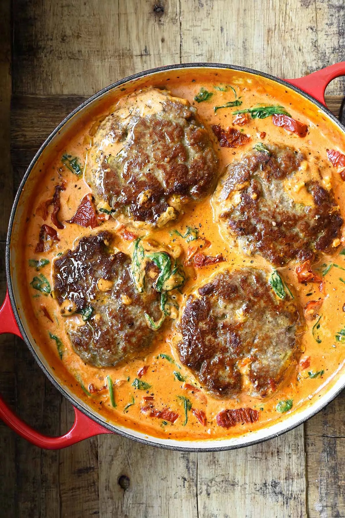 Protein Only 15oz: Tuscan Hamburger Steak — Seasoned beef patties simmered in a creamy garlic Parmesan sauce with spinach & sun-dried tomatoes.